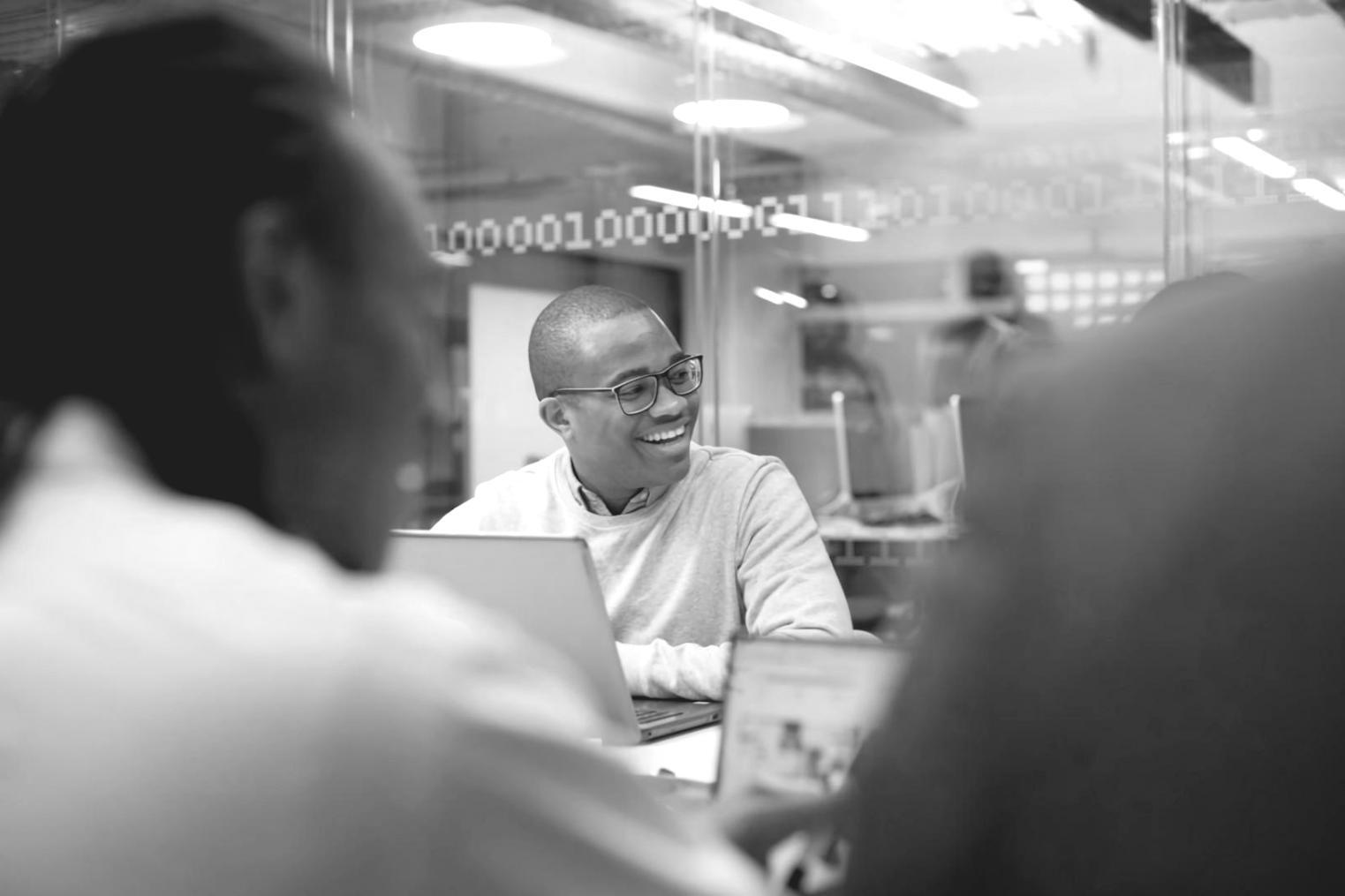 Financial analysts working on valuation models with multiple monitors displaying spreadsheets and market data